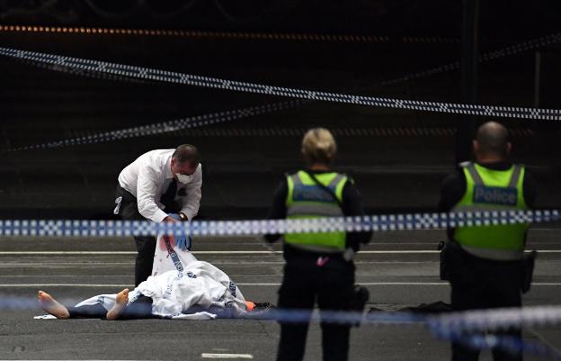 Un oficial de la Policía australiana cubre el cuerpo de la víctima mortal del atentado. :: afp
