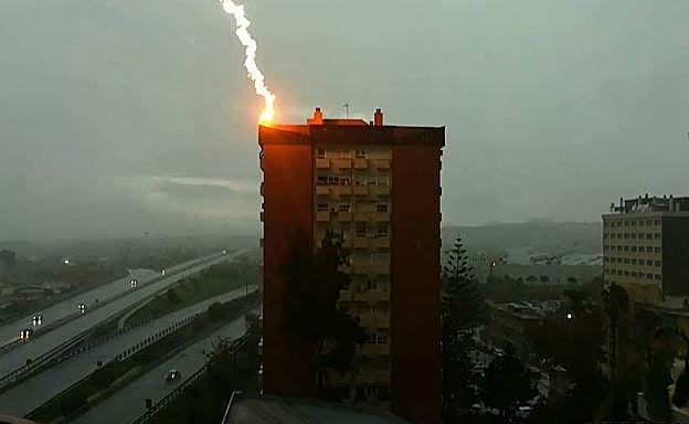 Impactante imagen de un rayo captada en la calle Corregidor Nicolás Isidro, en Málaga capital, este domingo.
