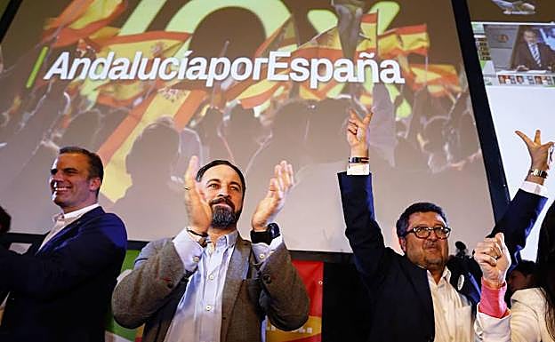 Santiago Abascal aplaude, mientras Francisco Serrano levanta los brazos con la señal de la victoria. 