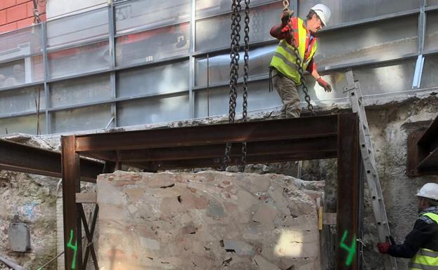 Obreros trabajando en la recolocación del muro.