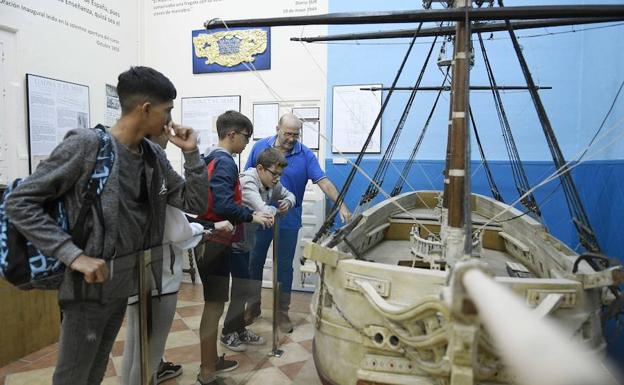 Estudiantes, con el profesor Ángel Ramírez, observan la maqueta de la corbeta expuesta en el aula de náutica del centro. 
