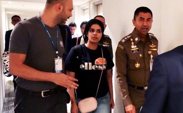 La mujer saudí Rahaf Mohammed al-Qanun (C) es escoltada por un oficial de inmigración (D) de Tailandia y funcionarios del Alto Comisionado de las Naciones Unidas para los Refugiados (ACNUR) (I).