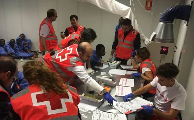Voluntarios de Cruz Roja atienen a un grupo de inmigrantes en Almería.
