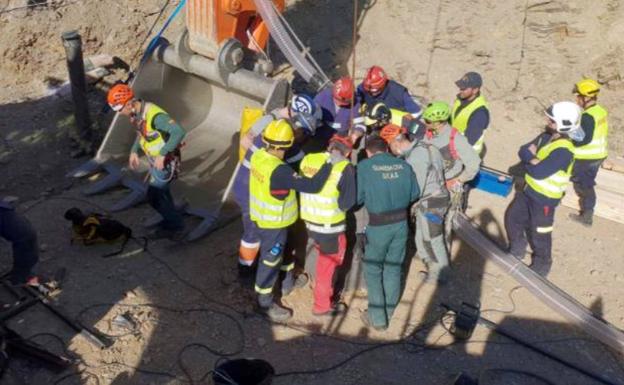 Miembros de la Brigada de Salvamento Minero, guardias civiles y bomberos, en la boca del pozo paralelo desde donde se trabaja en la excavación de la galería horizontal.