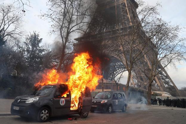 Un vehículo de la misión antiterrorista, incendiado en París. :: afp