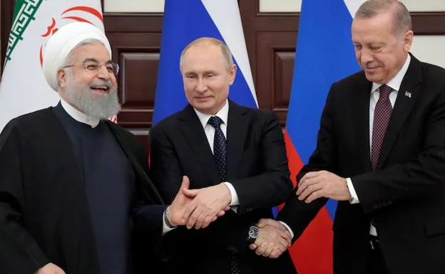 El presidente iraní, Hasán Rohuani; su homólogo ruso, Vladímir Putin, y el turco, Recep Tayyip Erdogan, se estrechan la mano durante su reunión este jueves en el balneario de Sochi. 