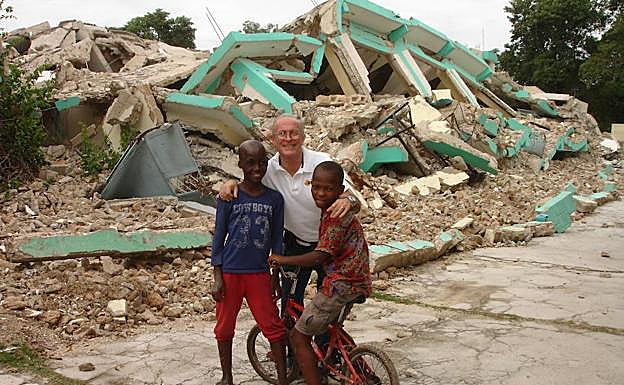 Linares, con dos niños haitianos tras el terremoto que asoló la isla. 