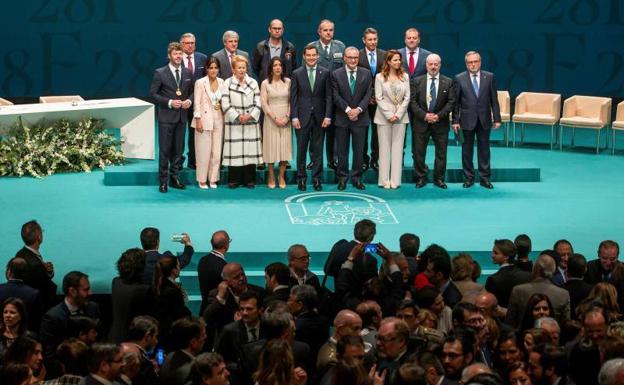 Imagen principal - El presidente andaluz, Juanma Moreno(c), acompañado de la presidenta del Parlamento, Marta Bosquet (4i), en la foto de familia con los premiados con las Medallas de Andalucía y los títulos de Hijos Predilectos. Entrega al representante de la Brigada Central de Salvamento Minero la Medalla de Andalucía que participó en el rescate de Julen. La cantante Pastora Soler, premiada con la Medalla de Andalucía, ha interpretado el himno andaluz durante el acto 