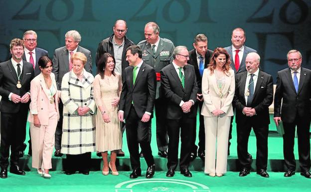 Juanma Moreno (c) acompañado de Marta Bosquet, junto a los premiados.
