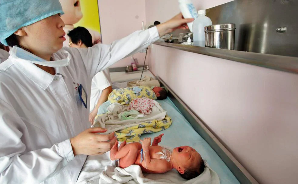 A la izquierda, sanitarios de un hospital de Shanghái atienden a varios recién nacidos.