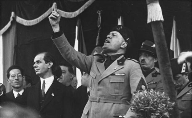 Imagen principal - Benito Mussolini arenga a las masas en Milán, en mayo de 1930. Abajo, El Duce desfila rodeado de militares por las calles de Roma, y los fundadores del fascio italiano, el 23 de marzo de 1919.