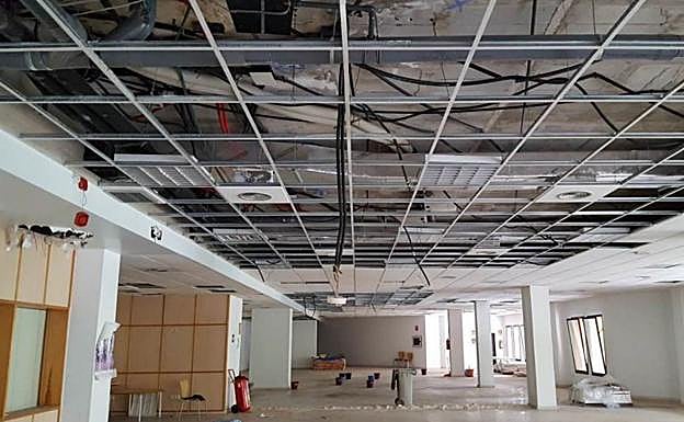 Imagen principal - Arriba, la biblioteca situada en los bajos se cerró en 2015. Abajo, a la izquierda, estado de la impermeabilización de la cubierta. A la derecha, interior de un puesto de pescado con problemas de estanqueidad. 