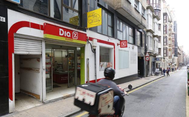 Un motorista pasa delante de un supermercado de la cadena Dia. 