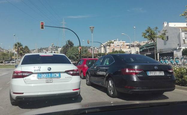 Imagen de archivo de un taxi y un VTC del mismo modelo en un semáforo de la capita malagueñal. 