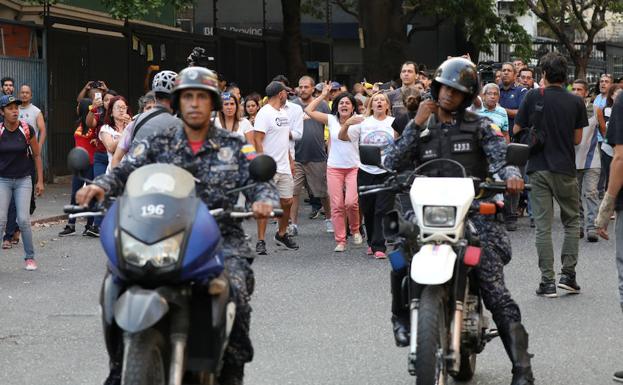 Simpatizantes de Juan Guaidó increpan a las fuerzas de seguridad chavistas en una calle de Caracas.