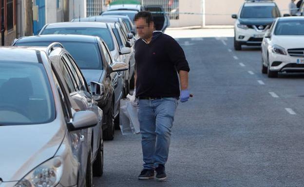 Un agente de la guardia civil porta varias bolsas con material recogido en el lugar del suceso.