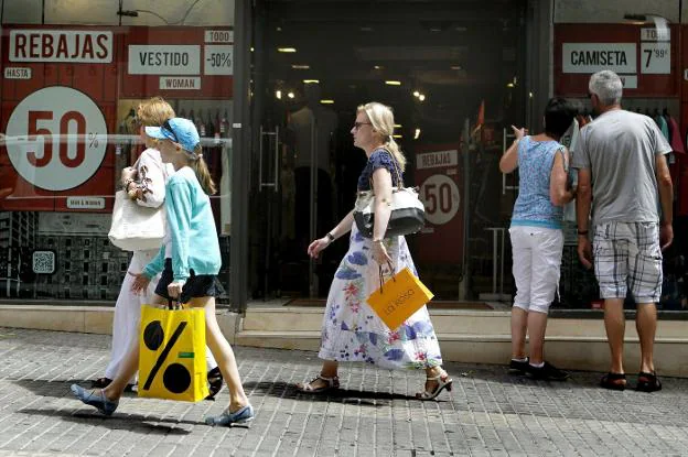 Consumidores en una calle comercial durante la época de rebajas. 