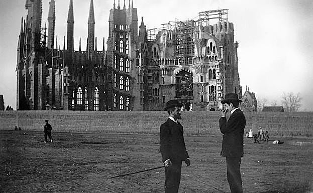Imagen principal - Arriba, la construcción, a principios del siglo XX. Abajo, a la izquierda, autobús turístico en el barrio donde se ubica el templo. A la derecha, un grupo de japoneses fotografían la basílica. :: efe