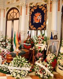 Imagen secundaria 2 - Málaga da su último adiós al poeta y articulista Manuel Alcántara. Francisco de la Torre, ha entregado la bandera de Málaga, que ha cubierto el féretro, a la hija de Manuel Alcántara Lola Porras