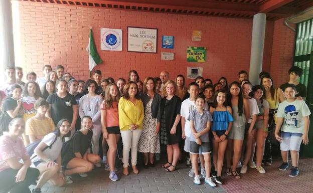 Un grupo de estudiantes, bajo la placa que reconoce la labor del centro. 