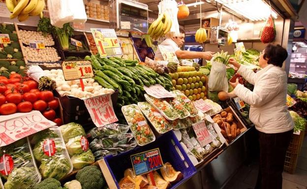 Una mujer comprando en la frutería.