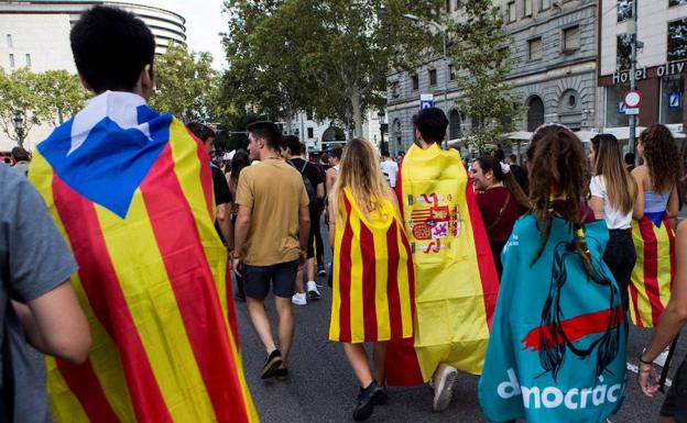 Dos jóvenes, una envuelta en la 'estelada' y otro en la bandera española, durante una manifestación estudiantil en Barcelona. 