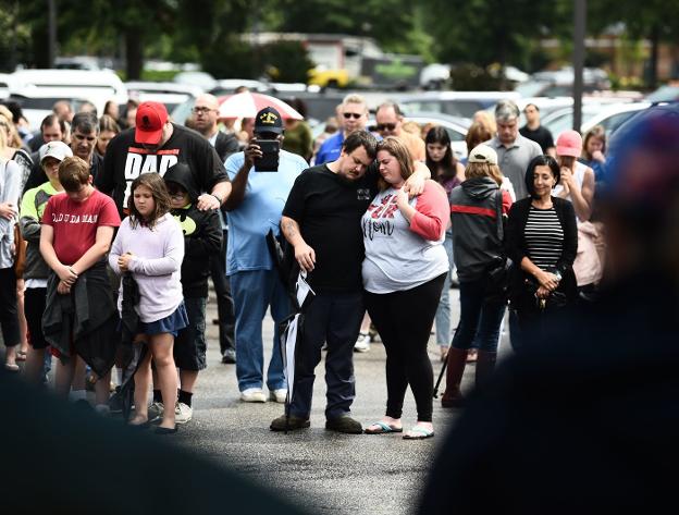 Los dolientes oran por las víctimas del tiroteo durante una vigilia improvisada en un centro comercial en Virginia. :: afp