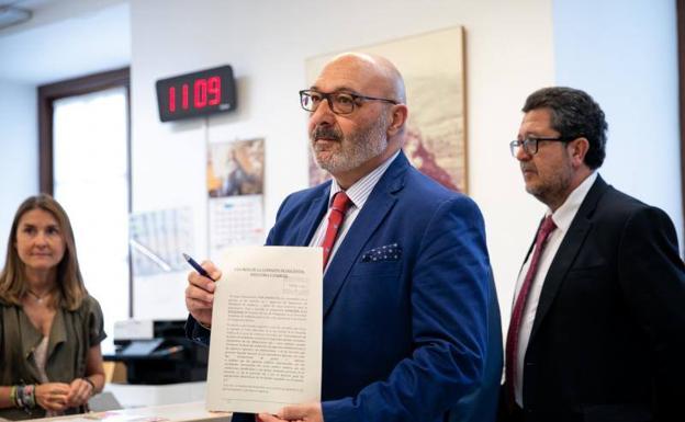 El portavoz del grupo parlamentario, Alejandro Hernández, junto al presidente del grupo parlamentario de Vox, Francisco Serrano, muestra el documento. 