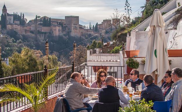 Herencia cultural. Turistas en un carmen del Albaicín, con la Alhambra al fondo.