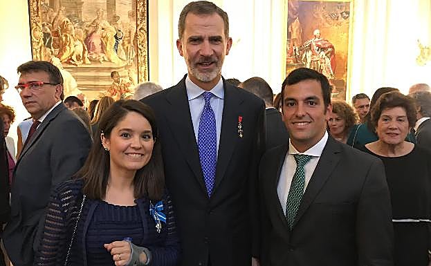 Imagen principal - Arriba, Serrano posa junto a Felipe VI y su pareja. Abajo, foto de familia de los condecorados y detalle de la cruz. 