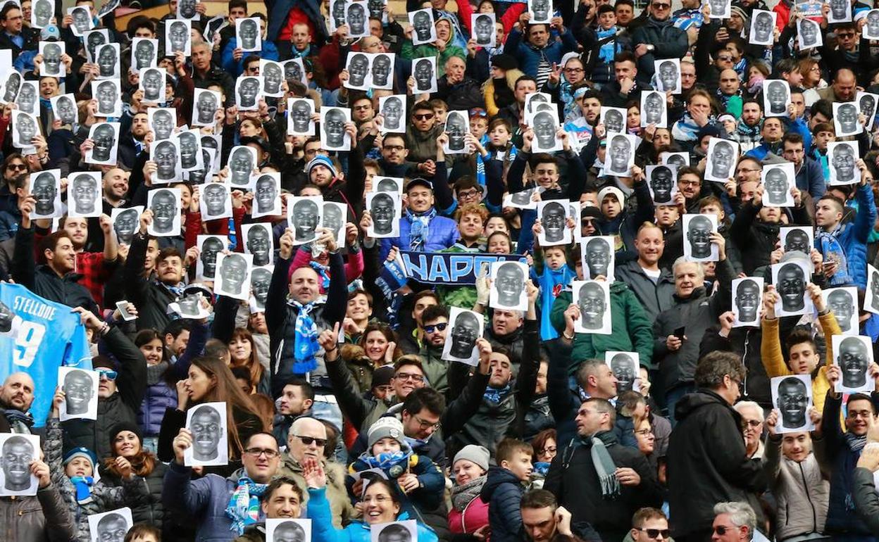 Hinchas mostrando carteles con la cara del futbolista del Nápoles Kalidou Koulibaly, objeto de cánticos racistas en un partido. 