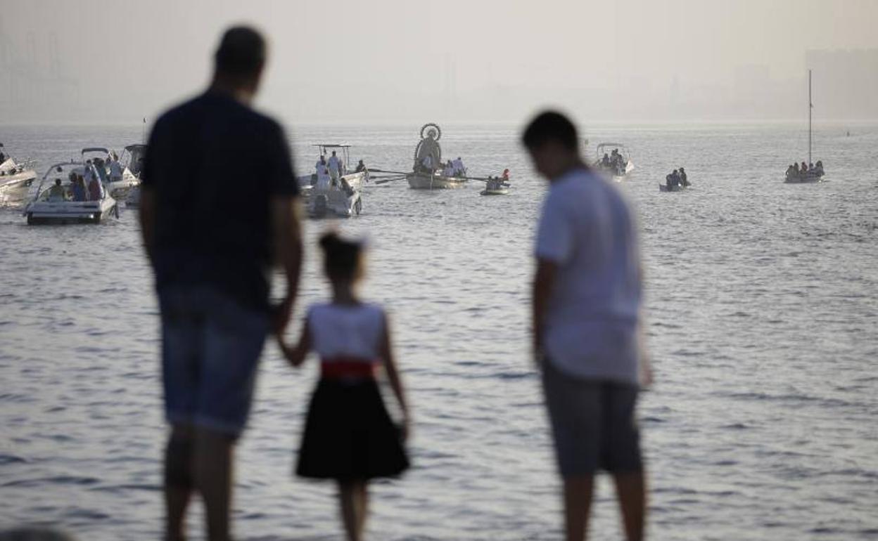 Pedregalejo. Una familia observa desde la playa la procesión marítima de la Virgen del Carmen. 