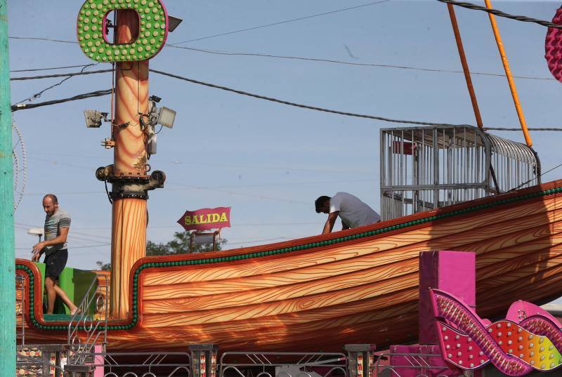 Feriantes, operarios municipales y de contratas y peñistas llevan semanas afanados en poner a punto todos los elementos que conforman esa ciudad efímera que es el Real de Cortijo de Torres.
