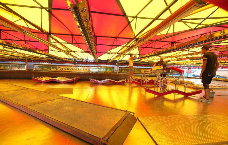 Feriantes, operarios municipales y de contratas y peñistas llevan semanas afanados en poner a punto todos los elementos que conforman esa ciudad efímera que es el Real de Cortijo de Torres.