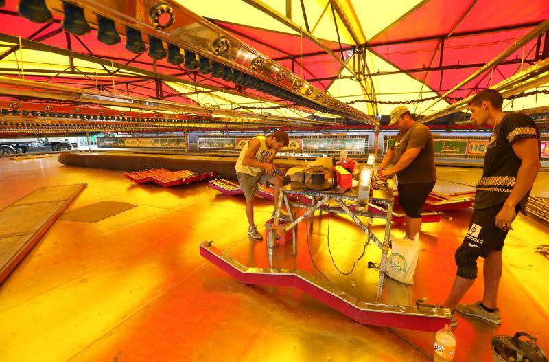 Feriantes, operarios municipales y de contratas y peñistas llevan semanas afanados en poner a punto todos los elementos que conforman esa ciudad efímera que es el Real de Cortijo de Torres.