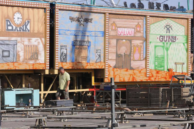 Feriantes, operarios municipales y de contratas y peñistas llevan semanas afanados en poner a punto todos los elementos que conforman esa ciudad efímera que es el Real de Cortijo de Torres.