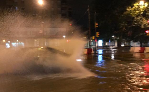 Un coche pasa por las bolsas de agua acumulada en poco tiempo en la Avenida de Andalucía de Málaga, durante la madrugada.