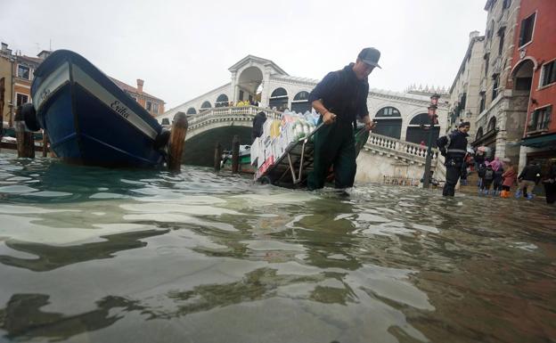 Un repartidor intenta avanzar por una Venecia inundada.