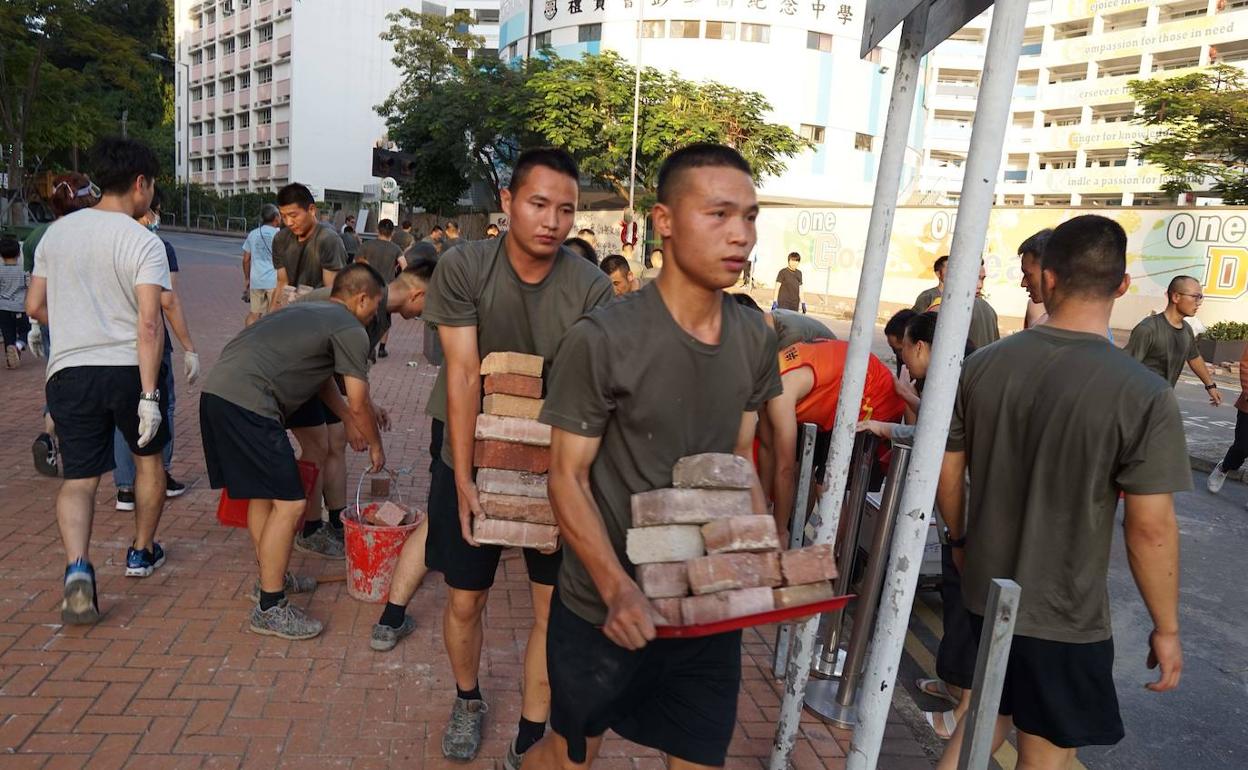 Soldados chinos limpian de escombros las calles de Hong Kong.