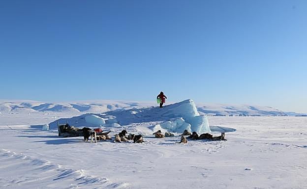 Manolo Calvo posa con el pendón de Málaga sobre un montículo de hielo. 
