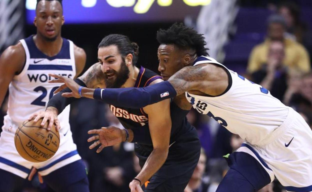 Ricky Rubio trata de zafarse de la defensa de Robert Convington. 