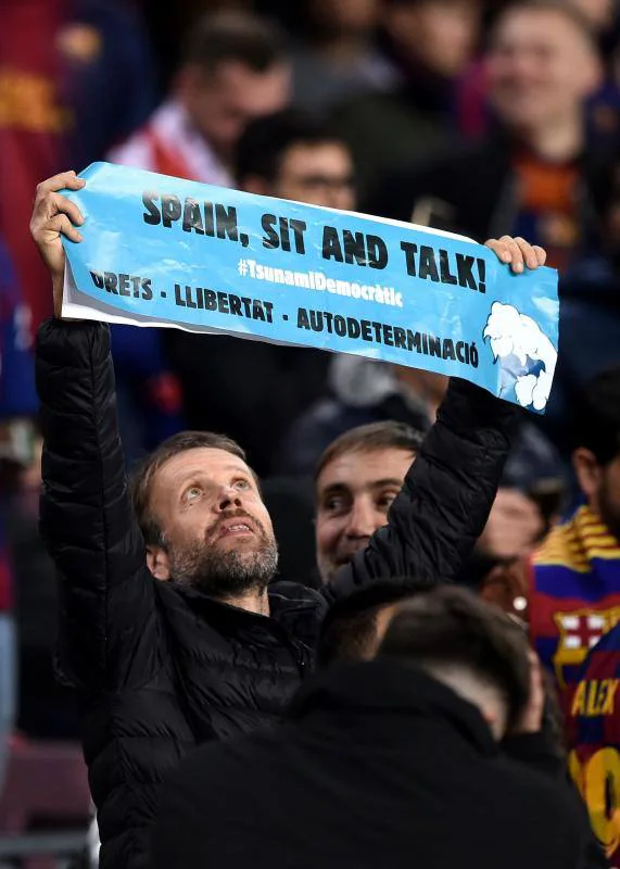 Un aficionado muestra una pancarta con el lema 'España, siéntate y habla'.