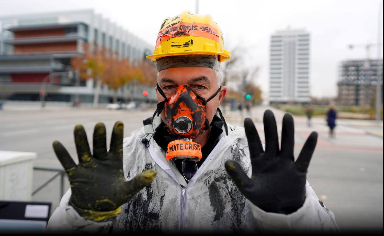 Madrid fue uno de los últimos escenarios del año en que hubo grandes protestas. En la fotografía aparece un activista en la puerta de la sede de Repsol en Madrid. Bloquearon el acceso como medida de protesta contra la compañía española que más CO2 emite a la atmósfera. 