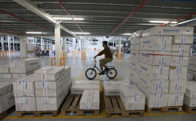 Imagen principal - El centro logístico recibe el producto, lo almacena y lo envía a los clientes. La rehabilitación respetó la estructura original. Los empleados se mueven en bicicleta. 