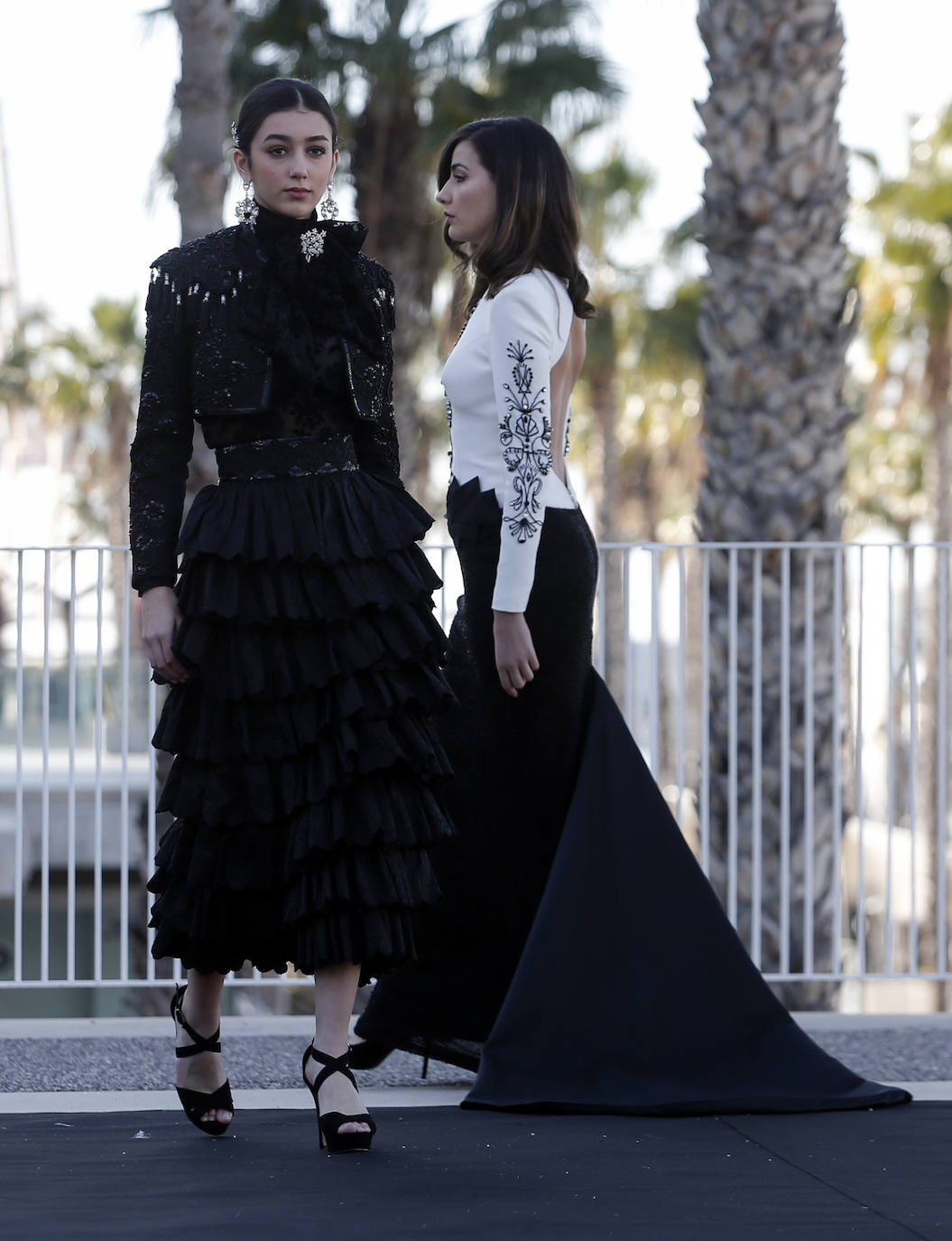 Apuesta en negro, con falda de volantes y chaqueta torera, de F de Frank. Al fondo, modelo de Javier Alcántara.