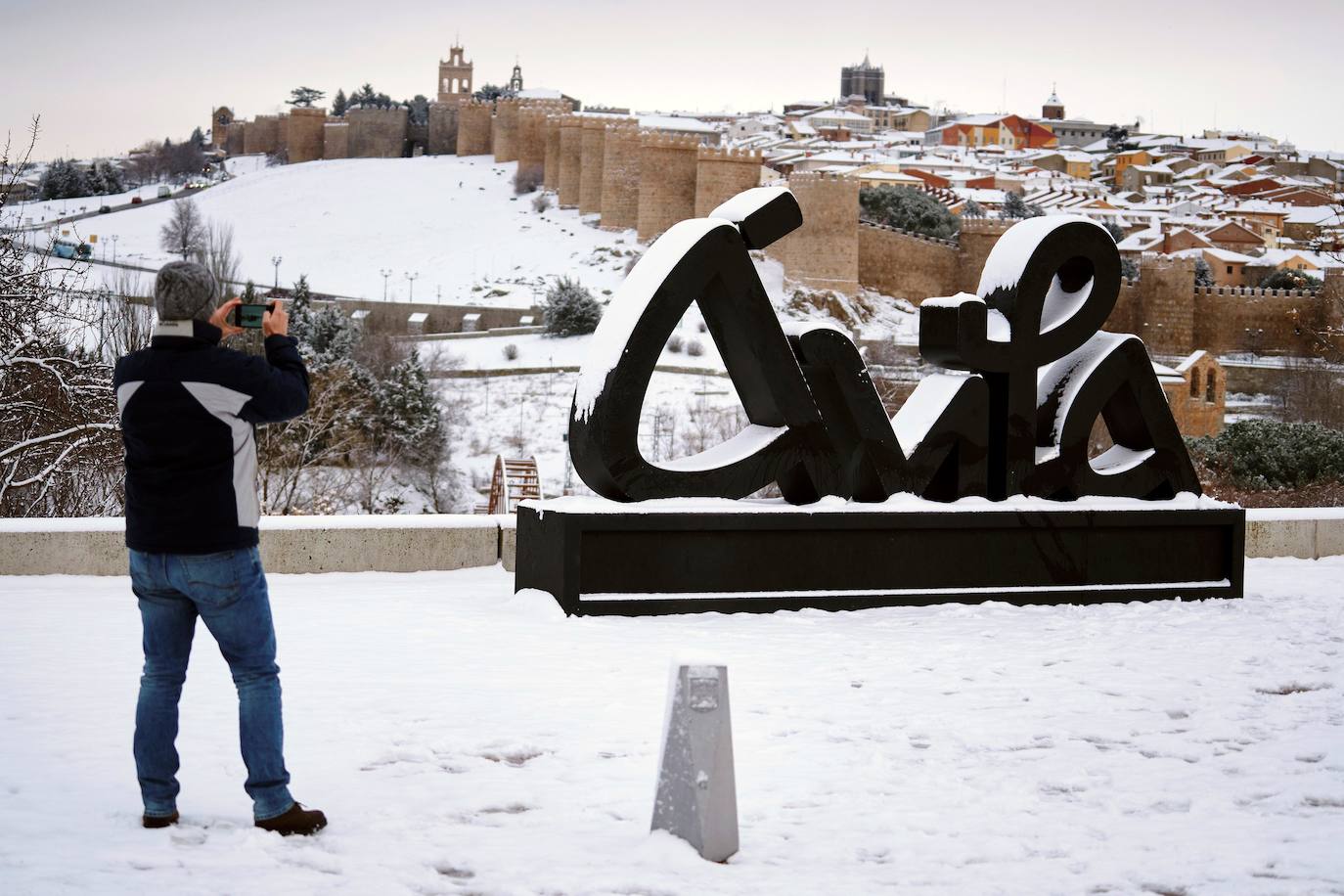 Un ciudadano toma fotos de la muralla de Ávila tras la fuerte nevada