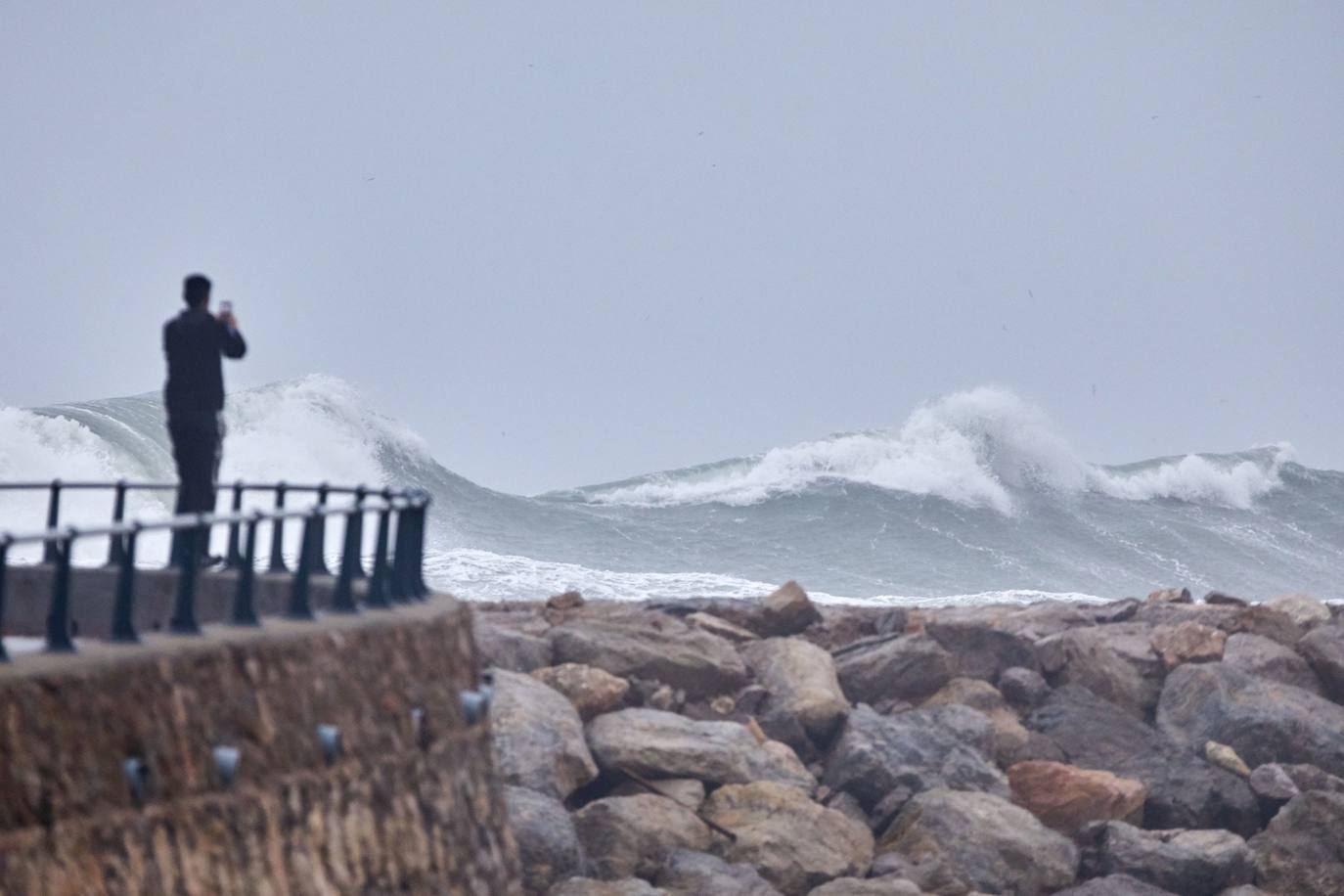 Una persona fotografía las grandes olas en L'Estartit (Girona)