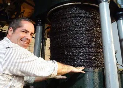 Imagen secundaria 1 - Los capachos reciben la presión de una prensa hidráulica de mediados del siglo pasado y la forma de hacer el aceite es la más artesanal posible para su posterior comercialización. Nacho Pérez representa la tercera generación de esta empresa familiar que va camino de los tres cuartos de siglo de historia. 