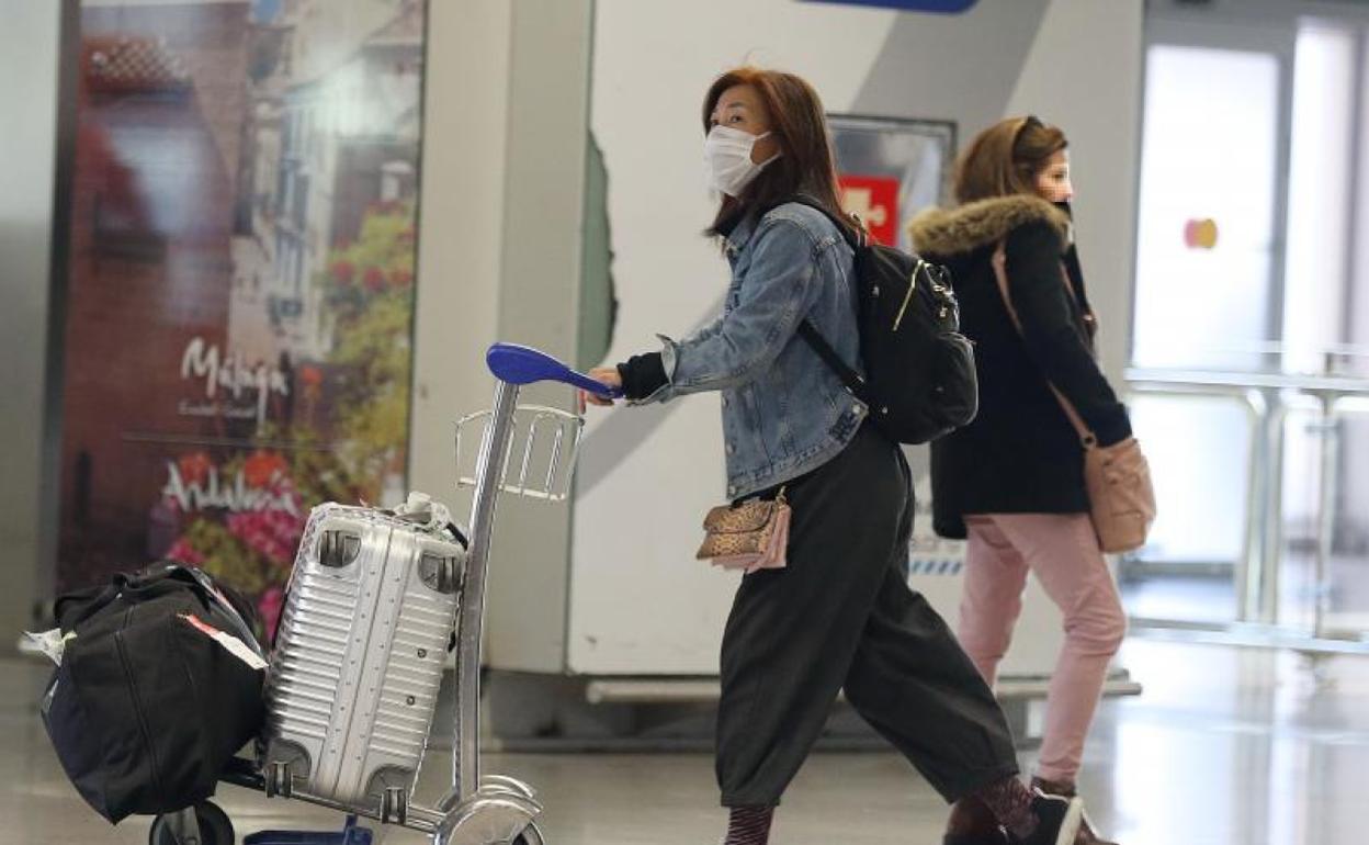 Una viajera llega al aeropuerto de Málaga, protegida con una mascarilla. 