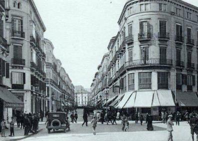 Imagen secundaria 1 - Arriba, fotografía tomada en 1907 de la entrada a la calle Larios desde la Acera de La Marina tras las inundaciones. Abajo, a la izquierda, la calle en el año 1925. Al lado, una imagen de la construcción de los edificios 